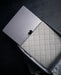 Close-up of the Eberlestock Fade Sling XL's padded laptop sleeve with a MacBook fitted inside, showing the quilted lining that protects electronics.