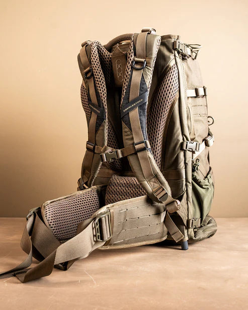 A rear angled view of the Eberlestock Spectre 50L Backpack showing the padded shoulder straps and hip belt in the foreground, with the breathable mesh back panel visible in the second plane to ensure maximum airflow for the operator.