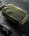 an image of the eberlestock fade flex micro in the olive variant and is being placed on a dark table beside a small pistol. 