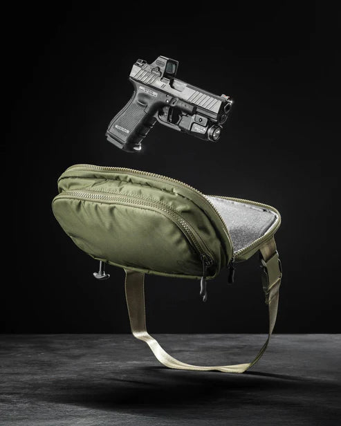 the image shows us the eberlestock fade flex micro in the color variant of olive and is suspended midair with a gun right above it trying to emphasize how the gun came from the product.