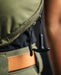 the image showcases the eberlestock fade flex micro in its olive variant and this image showcases the T-puller zipper feature that is danggling or attached on one zipper of the product and is dangling down