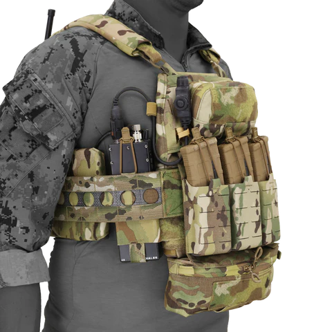 Front-left view of the FCPC V5 plate carrier worn on a mannequin, featuring a Multicam camouflage pattern, front magazine placard, side cummerbund storage, radio routing, and an attached dangler pouch.