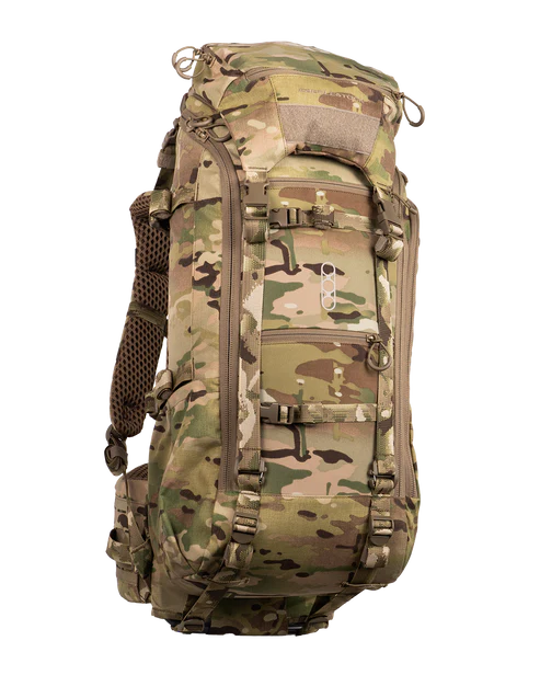 A frontal angled view of the Eberlestock Brute 3500 Multi-Day Hunting Pack in Multicam, showing how the specialized camo pattern blends into the environment while highlighting the rugged storage compartments.