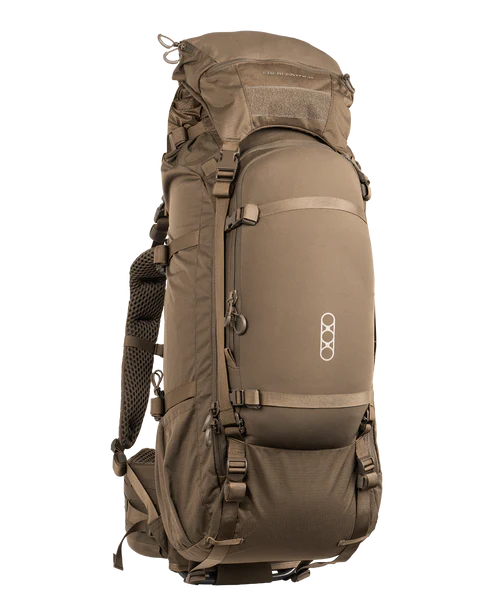 A frontal angled view of the Eberlestock Brute 6500 105L Hunting Pack in Dry Earth, displaying the rugged ripstop exterior and the integrated roll-top expansion sleeve for carrying oversized backcountry gear.
