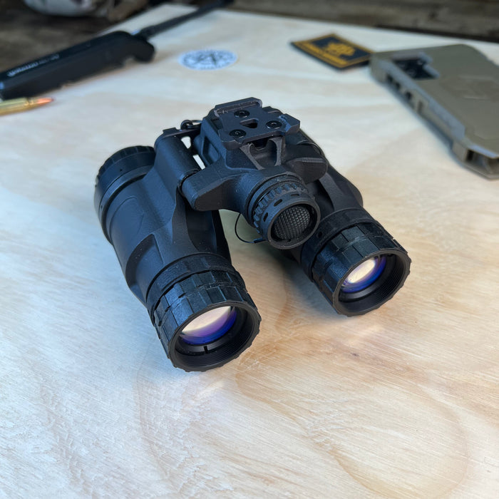 A frontal right-side view of the katana nvg showcases the battery compartment in the foreground while highlighting the uncovered diopter lenses at the rear of the device.