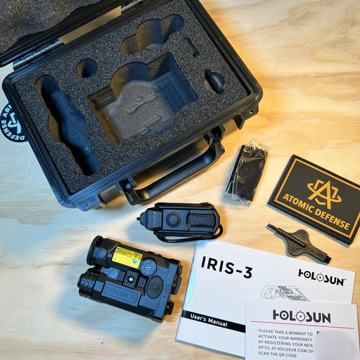 the holosun industries iris gr3 in the color black and with the case and its manual around it, and an atomic defense patch around.