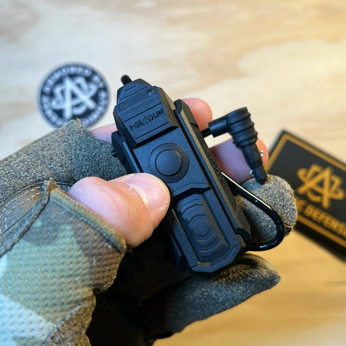 the holosun iris gr3 that is being held by a product model and is featuring the activation button of the item which is situated right below the brand name 