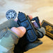 the holosun iris gr3 that is being held by a product model and is featuring the activation button of the item which is situated right below the brand name 