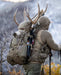 A mountain hunter expertly carrying a successful elk harvest on the Brute 4500 Load Hauling Pack, demonstrating the system's superior stability and weight distribution while managing 100+ lb loads on steep terrain.