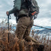 A hunter hiking across a field in Eberlestock Deadwood Long Trousers, displaying the range of motion provided by the articulated knees.