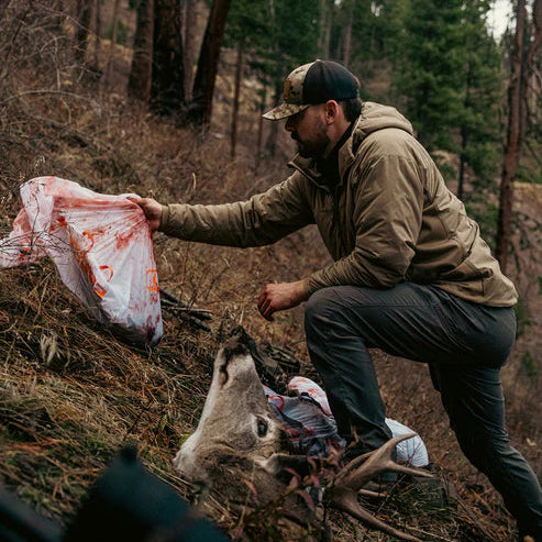 Hunter processing a deer trophy while wearing the water-repellent Eberlestock Alturas Hooded Jacket.