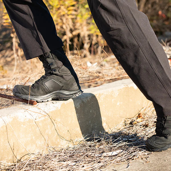 A lifestyle image showing an operator wearing the Salomon XA Forces 8 GTX men's boot outdoors, stepping confidently on a rugged, rocky trail to demonstrate its real-world stability.