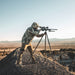 man-aiming-a-tripod-mounted-rifle-wearing-skye-eberlestock-mccall-hooded-down-jacket