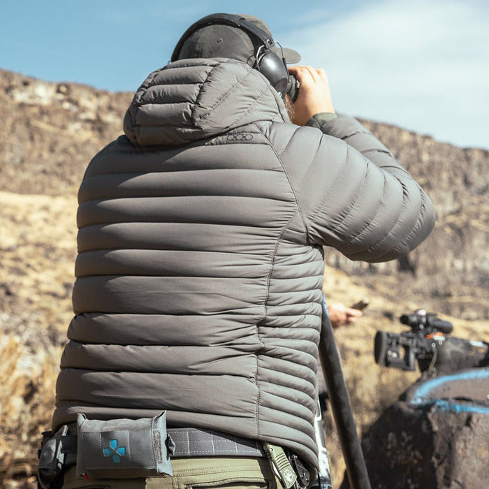 man-looking-through-binoculars-wearing-gunmetal-eberlestock-mccall-hooded-down-jacket