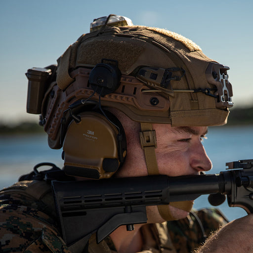 member of armed forces wearing tan high-cut hellbender te helmet while aiming a rifle