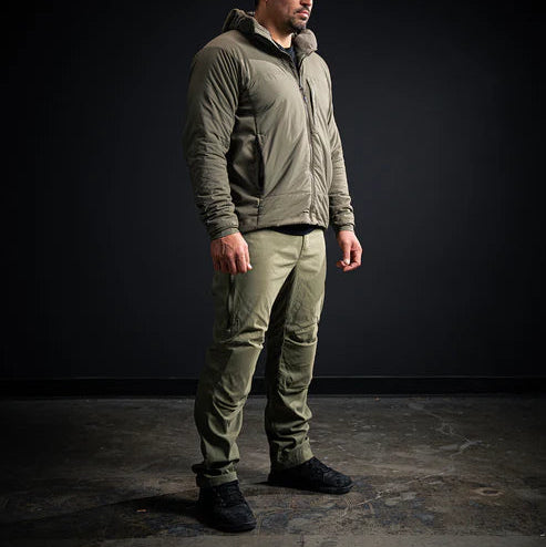 A Mexican model wearing the Fall Green Eberlestock Camas Professional pants paired with an Eberlestock Alturas jacket for a complete outdoor system.