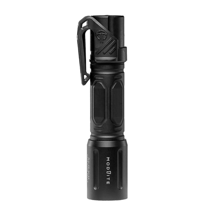 An image of the modlite multi-mode handheld plhv3 18650 flashlight showcasing the black tactical flashlight in the middle of the photo and with a textured grip and white product lettering detailing its dual fuel, multi-mode capabilities on a reflective surface and with the thyrm low profile clip attached to it.