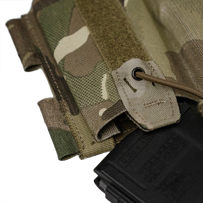 A detailed close-up of the MultiCam magazine pouch, highlighting the rigid re-indexing tab and the secure Shock cord routed through a metal eyelet to firmly hold a black rifle magazine in place.