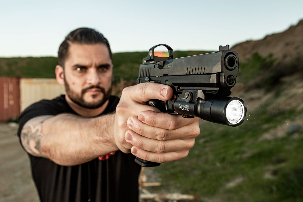 An operator firing a Glock 17 equipped with the high-candela SureFire X300 Turbo at Raahauge's Shooting Range, highlighting the weapon light's secure fit during live fire