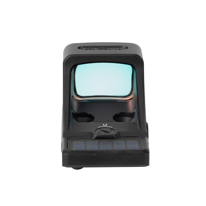 A first-person point of view shot looking directly through the rear of the VP9 SCS reflex sight mounted on a handgun, showing the clear glass window and a sharp green dot aligned cleanly with the target.