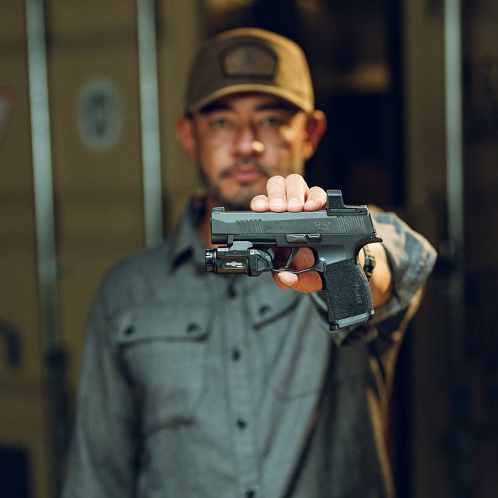 A side profile shot of our product manager holding a Glock 43X with the SureFire XC3 Sub Weaponlight attached, showing the seamless and flush fit against the pistol's subcompact frame.