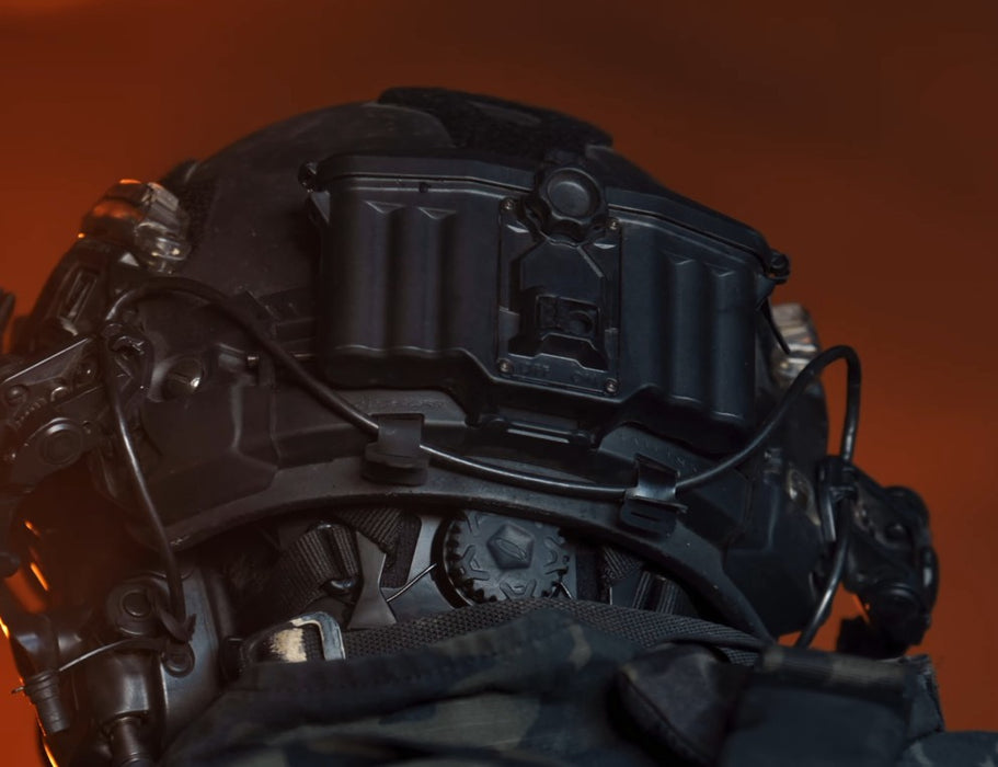 Rear lifestyle shot of an operator wearing the new FAST XP helmet system in black, featuring a rear-mounted NVG battery pack with clean cable routing through the PowerPath rails and the Head-Loc retention dial visible at the nape.