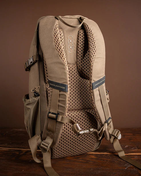 A detailed rear shot of the Eberlestock Brute Scout Pack showcasing the integrated air-mesh back panel and contoured shoulder straps, with the adjustable sternum strap secured to ensure a stable and comfortable fit during movement.