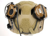 A rear view of an Ops-Core FAST bump helmet showing 3M Peltor ComTac V headsets rotated and stowed toward the back of the shell using the unity mark 2.0 mount to maintain a snag-free, low-profile configuration.