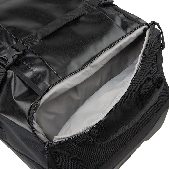 A detailed close-up shot of the Road Less Traveled 100L Duffel Roller highlights the 15-liter expandable side pocket, designed to provide quick access to high-priority essentials without having to open the main bag.