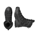 A high-angle studio shot shows a pair of all-black salomon boots from the Quest CW Forces WP EN line, with one boot standing upright and the other lying on its side to reveal the detailed traction pattern and side reinforcement.