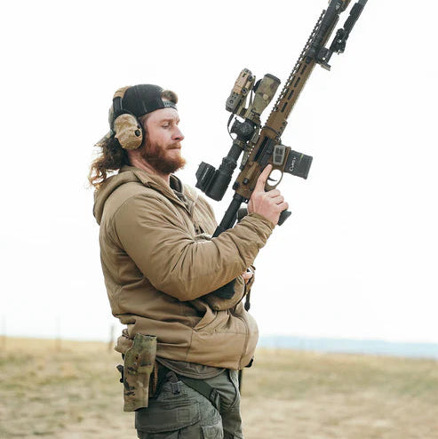 Shooter preparing to fire an AR-15 while wearing the Eberlestock Alturas Hooded Jacket at the range.