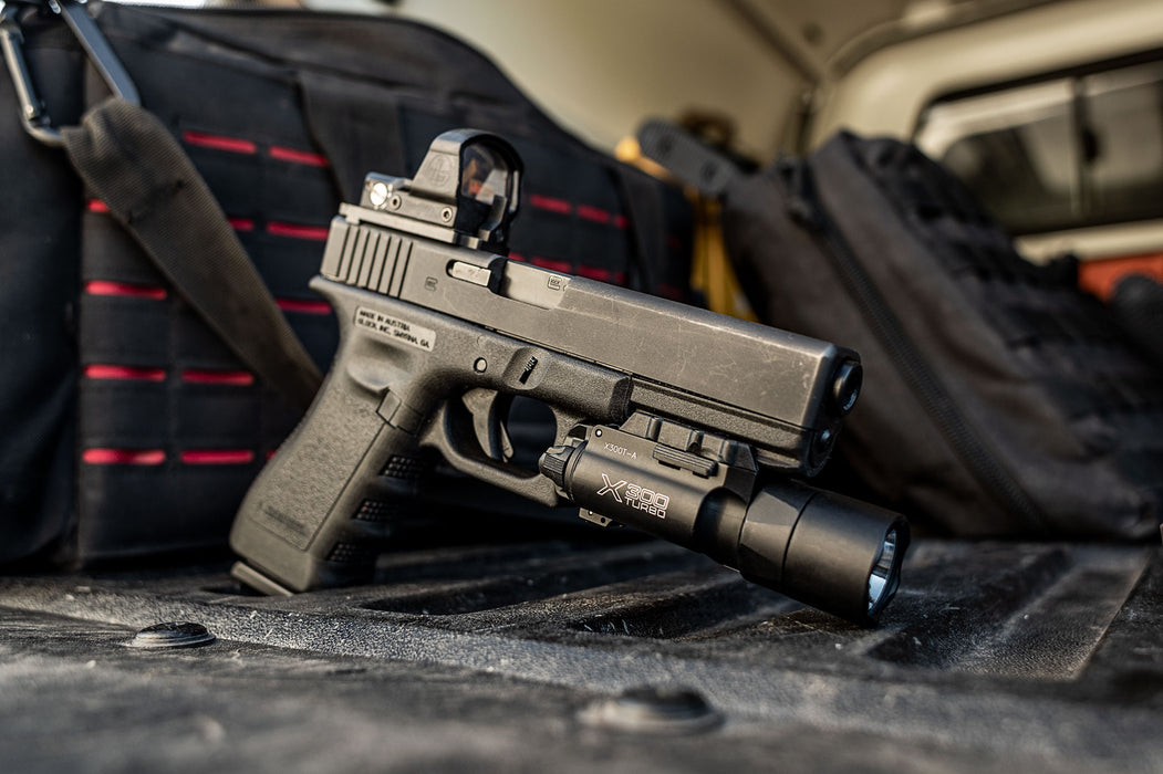 A side profile view of a black SureFire X300 Turbo mounted on a Glock 19, showing how the light aligns flush with the pistol's muzzle for a compact carry profile