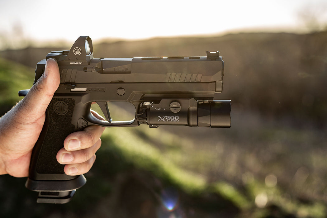 A side profile view of the SureFire X300T-B mounted on a Sig Sauer P226, demonstrating the secure fit of the T-Slot mounting system on a metal-framed duty pistol.