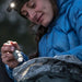 woman in blue jacket using the surefire g2x pro to search inside her pack