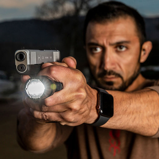 man holding g2zx combat flashlight with pistol 