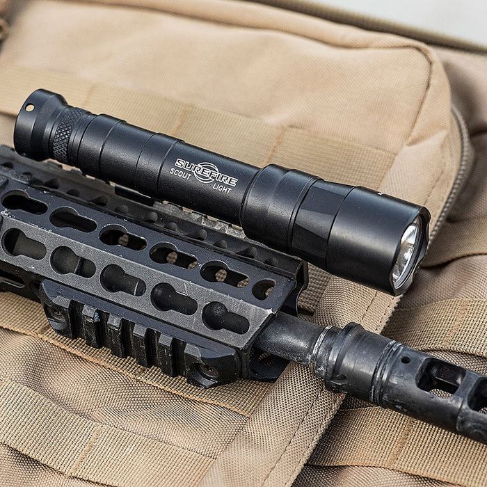 surefire-m640dft-pro-turbo-series-6-volt-dual-fuel-scout-light-pro-weaponlight-black-mounted-on-rifle-on-top-of-a-tactical-pack-with-molle