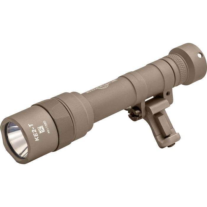 A left-side isometric view of the SureFire M640T-TN-PRO, displaying its desert-ready tan finish and the hinged mounting system designed for seamless rail integration.
