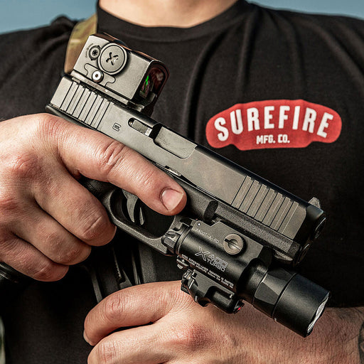 man holding pistol with mounted surefire x400t in low-ready position