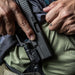 operative about to holster handgun with black surefire xc20-b weaponlight