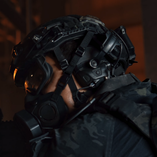 A SWAT operator wearing the new Ops-Core FAST XP Helmet System in black, demonstrating seamless integration with the Ops-Core ecosystem by utilizing AMP headsets on vented arms, a SOTR respiratory mask, and a Step-In Visor.