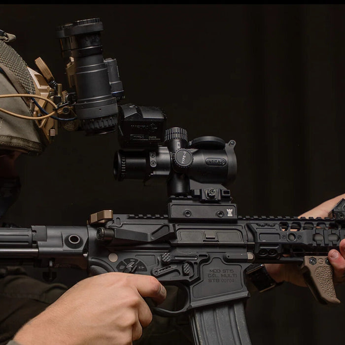 Tactical operator aiming through an Infitac IOL25 Thermal Sight mounted on an AR-15 rifle.