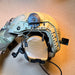 A side angle of a tan high-cut ballistic helmet showing the helmet rail attachment system firmly securing a coyote brown Peltor ComTac VIII hearing protection earcup.