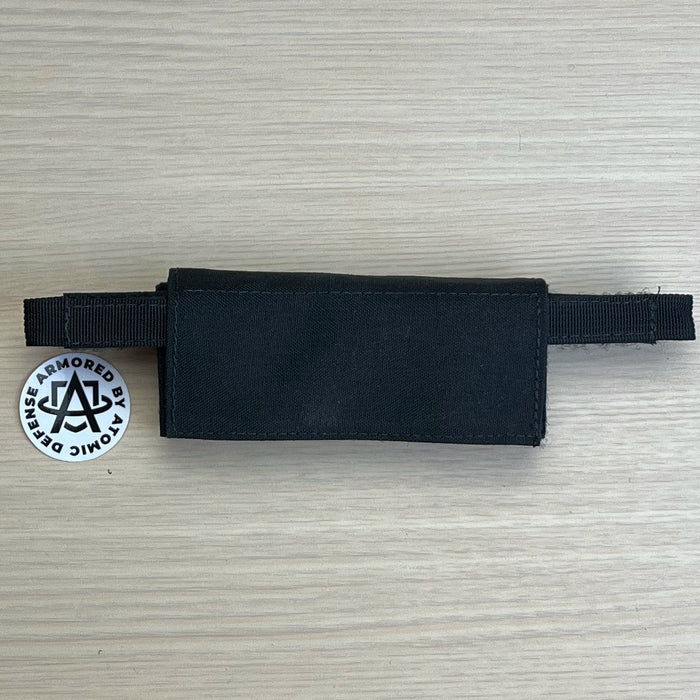 A high-detail photo of the black Team Wendy EXFIL counterweight kit in size large, displaying the three heavy-duty lead weights and the rugged nylon pouch designed to balance 1.5 lbs of headborne gear.