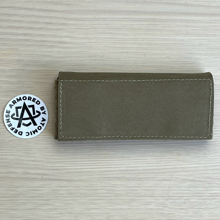 A high-resolution photo of the Ranger Green team wendy exfil counterweight kit in size large, showing the three 0.5 lb weights and the heavy-duty nylon pouch designed to balance 1.5 lbs of headborne gear.