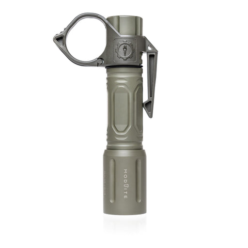 An image of the Thyrm Switchback 2.0 pocket clip in the color sage green, attached to a Modlite handheld 18650 flashlight, where the product is situated in the middle and is standing on the flashlight's light head.