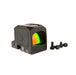 an image showing an isometric right side view of the Trijicon RCR closed emitter red dot sight against a plain white background with the left side panel features a prominent circular Trijicon logo, and above it and the top of the body holds the battery cap with a coin slot and right beside are the screws that come for its mounting