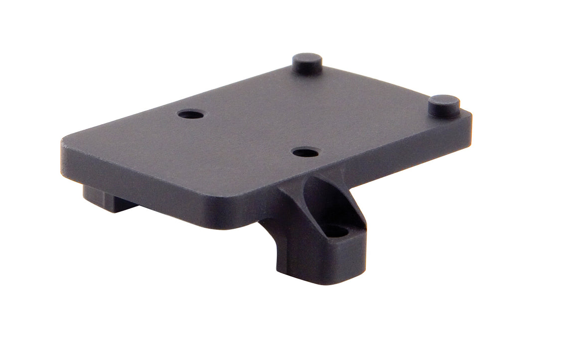 a product image of the trijicon rmr footprint mount in  back isometric view featuring a small, flat, rectangular platform featuring four distinct protrusions that are two round recoil pins and two thread screw holes and in the color black.