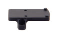 a product image of the trijicon rmr footprint mount in its backview featuring the product that small, flat, rectangular platform featuring four distinct protrusions that are two round recoil pins and two thread screw holes and in the color black and with a side screw hole to plug directly into the bottom of the optic to absorb physical force