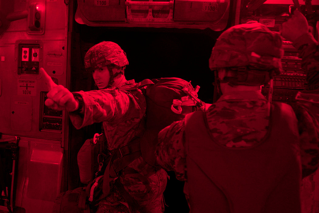 Two airborne operators waiting for the green go signal from the CORE Survival Portable Jump Light before exiting the aircraft.