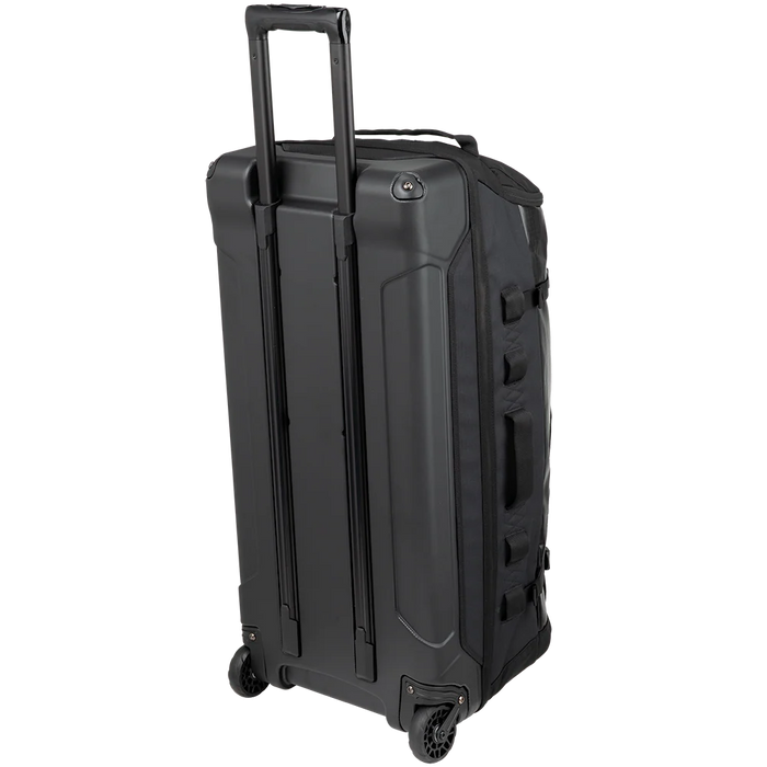 A frontal side view of the Vertx RLT 100L Duffel Bag Roller highlights the sleek aluminum retractable handle in the foreground , emphasizing the structured body built to stand upright during travel.